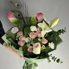 Bouquet of flowers with a peacock feather White pink and green flowers