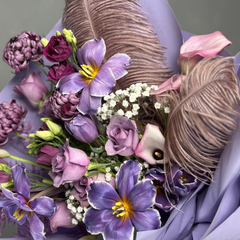 Bouquet of flowers with purple and pink tones, including feathers
