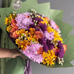 Bouquet of colorful flowers held by a person with 'Floraty' branding.