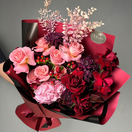Bouquet of pink and red flowers with a 'Floraty' tag on a gray background

