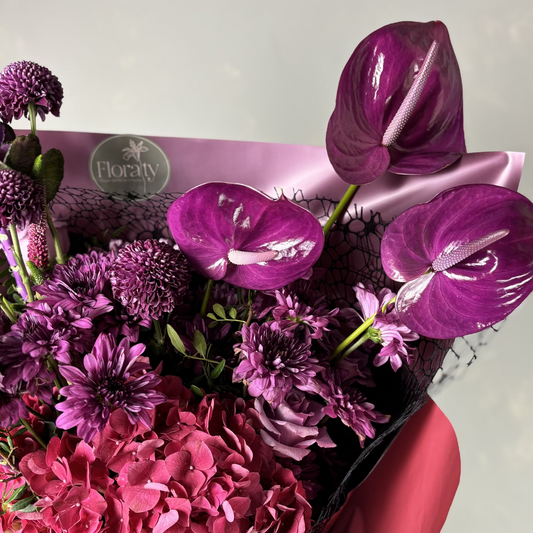 Bouquet of purple and pink flowers with a visible 'Floraty' brand label.