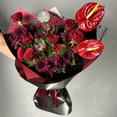 Bouquet of red flowers with a black wrap on a gray background