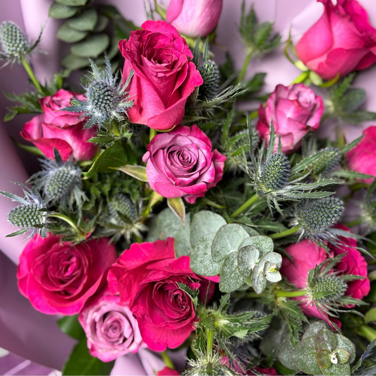 Bouquet of pink roses with greenery, branded 'Floraly' in the background.

