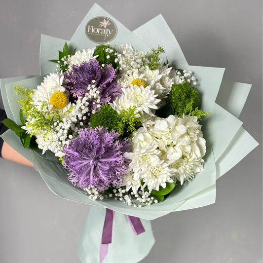Bouquet of flowers with purple and white flowers, greenery, and a visible 'Floraty' logo.

