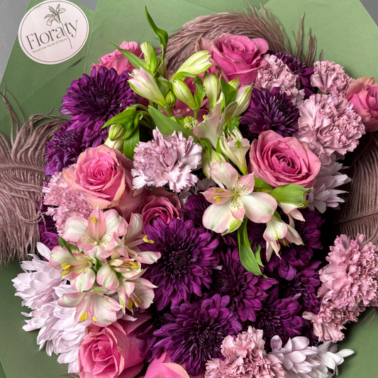 Bouquet of flowers with pink, purple, and white colors on a green background

