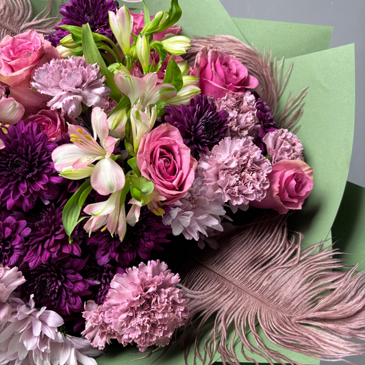 Bouquet of flowers with pink, purple, and green colors on a green background