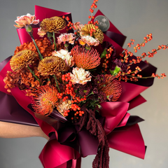 Bouquet of flowers with orange and cream flowers on a neutral background